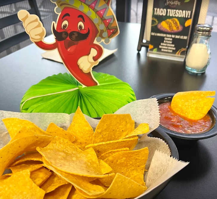 Basket of tortilla chips with a bowl of red salsa